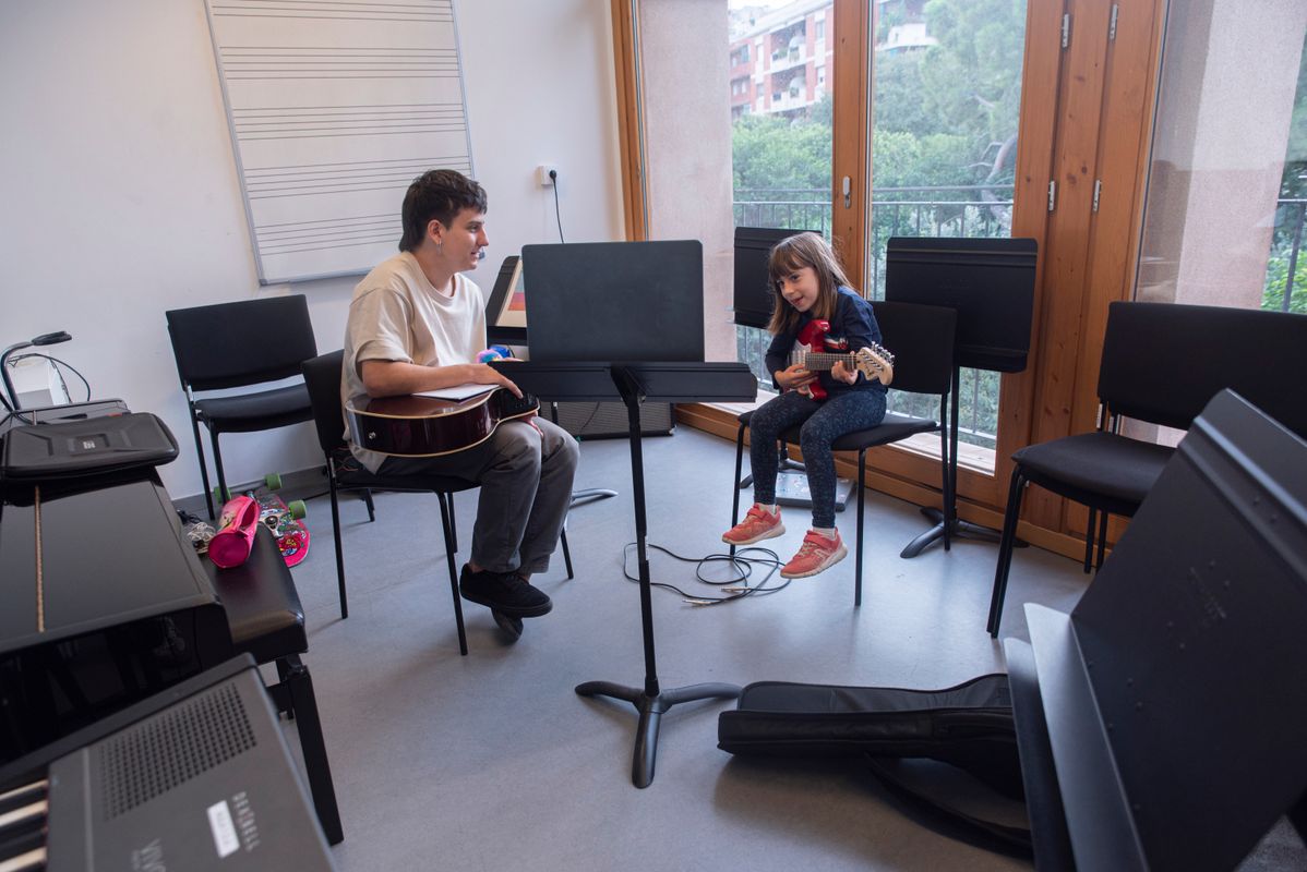 
             Una nena petita aprèn a tocar la guitarra elèctrica a una de les classes de l...
             Autor: Joanna Chichelnitzky
             Mostra els detalls de la imatge Una nena petita aprèn a tocar la guitarra elèctrica a una de les classes de l...
             