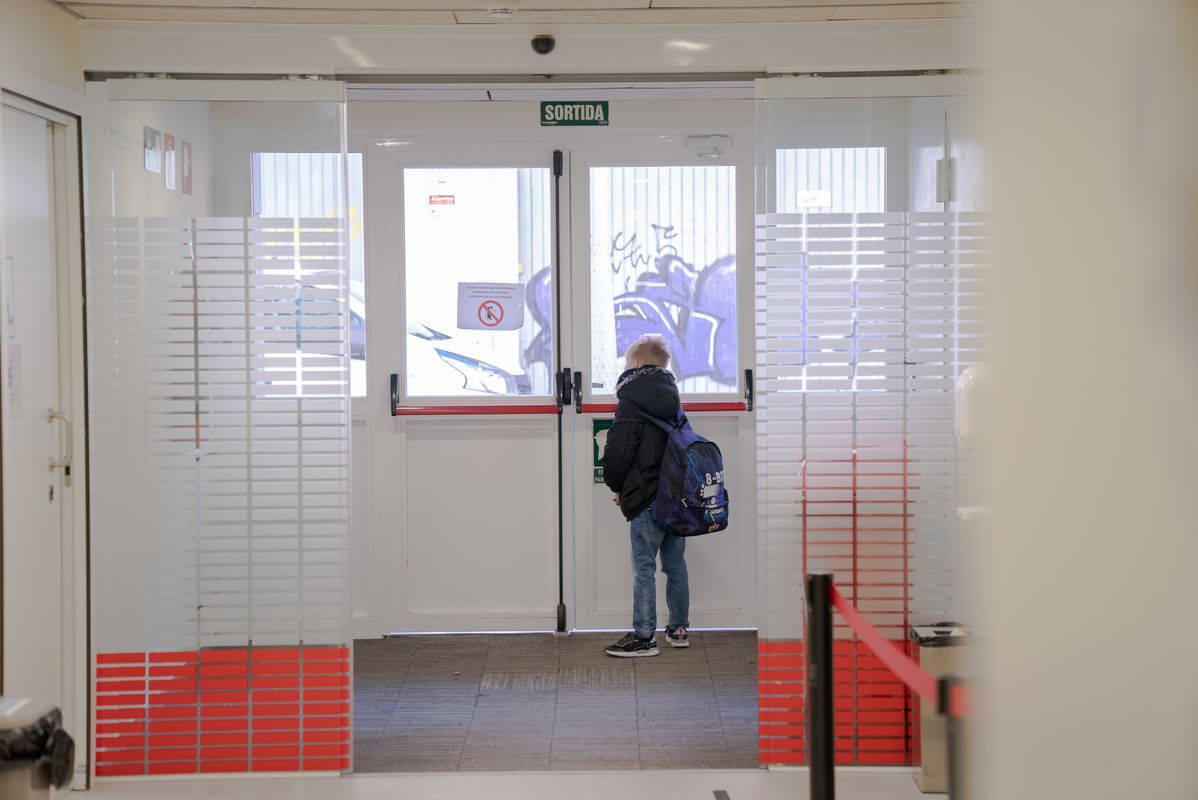 
             Un infant mira a través de les portes de vidre del nou centre d