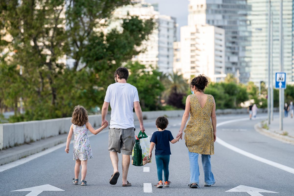 
             Una família passeja de la mà per la calçada de l