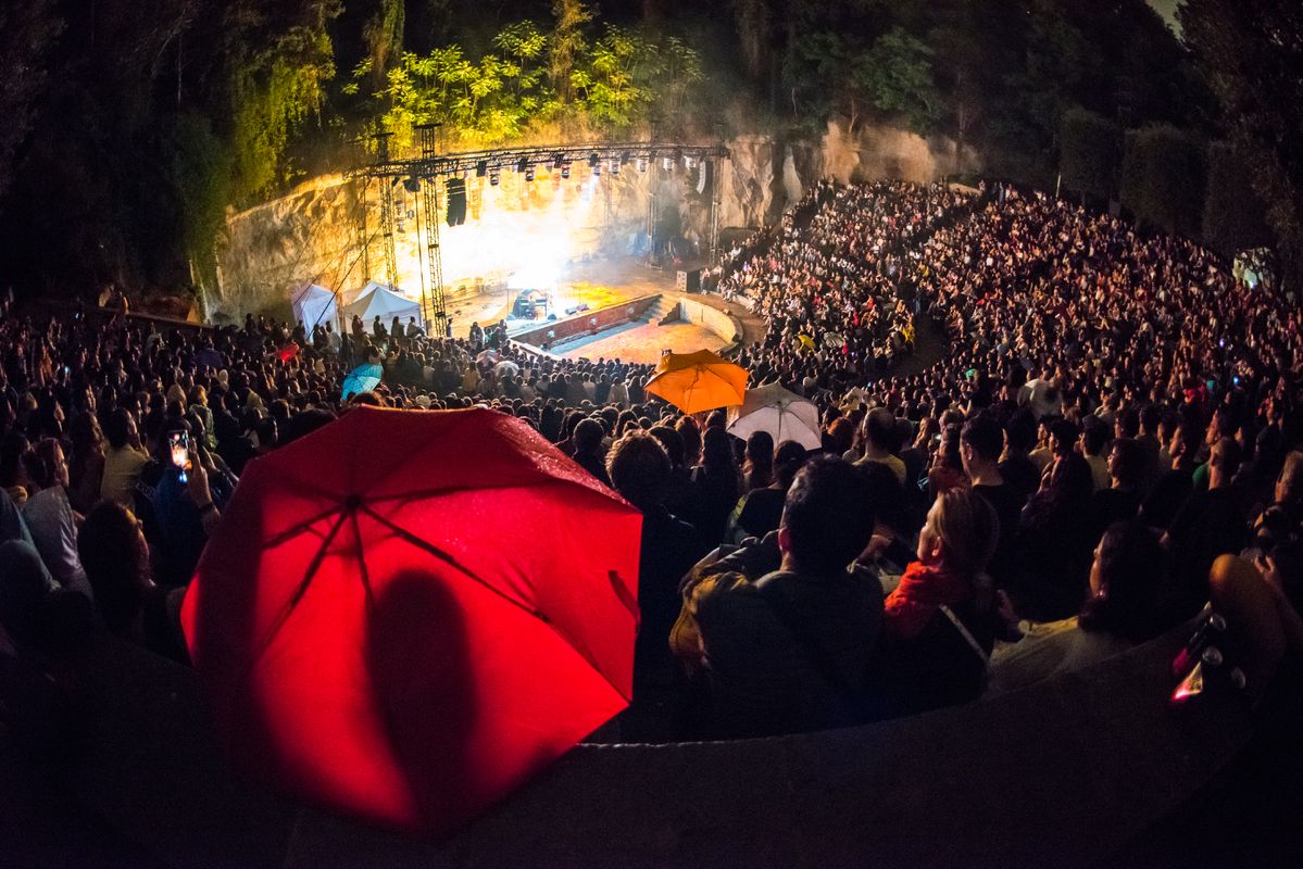 
             Una persona del públic del Teatre Grec es protegeix de la pluja amb un paraig...
             Autor: Víctor Parreño Vidiella
             Mostra els detalls de la imatge Una persona del públic del Teatre Grec es protegeix de la pluja amb un paraig...
             