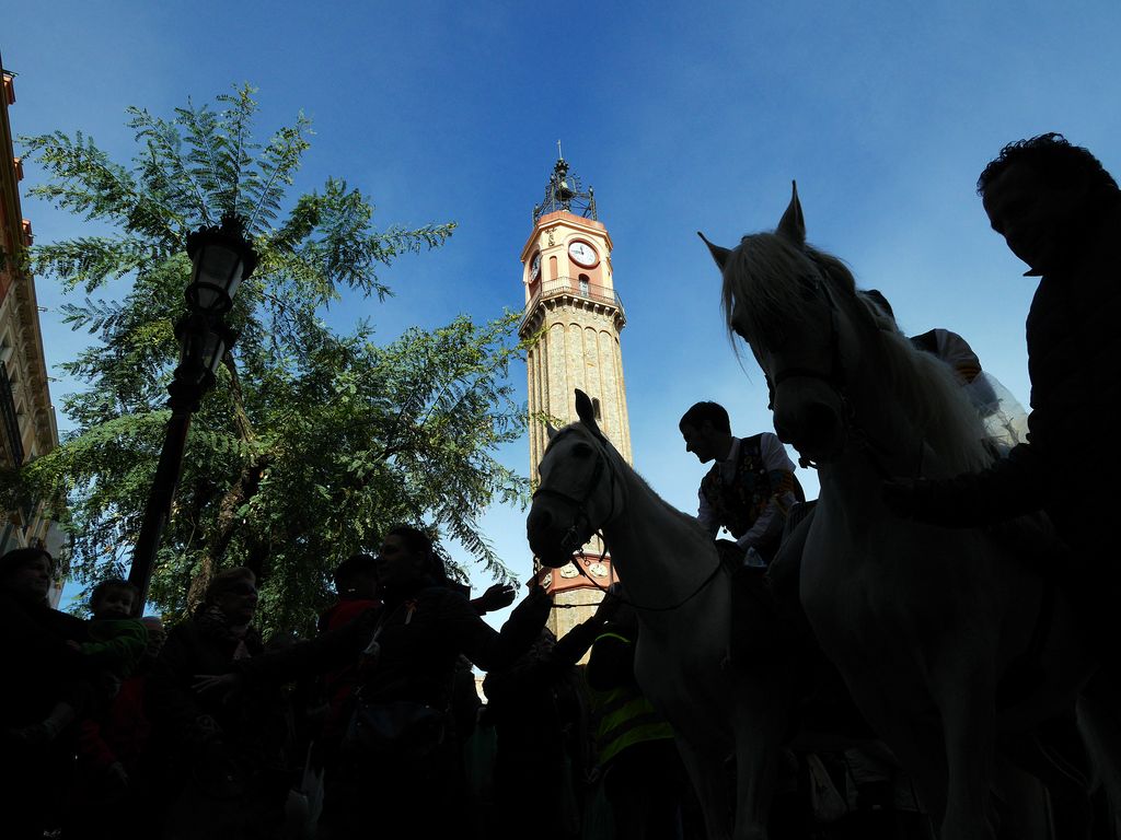 Sant Medir en Gràcia. Repartiendo caramelos a caballo bajo la Torre del Rellotge