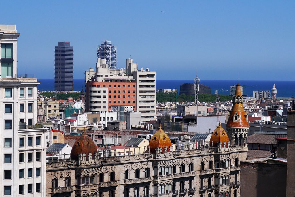 Vista parcial de Barcelona amb la Casa Rocamora a primer terme i el litoral al fons