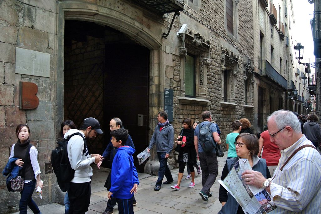 Museu Picasso. Visitants entrant i sortint per la porta principal al carrer de Montcada