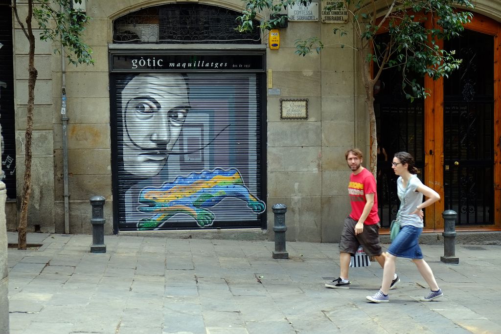 Grafit a la persiana d'una botiga amb Dalí i el drac del Park Güell