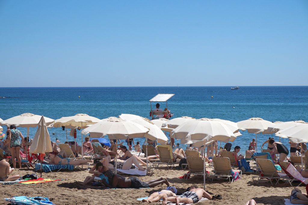 Banyistes a la platja de la Barceloneta. Para-sols i socorrista