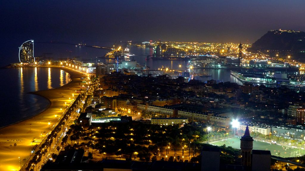 Vista parcial de l'Eixample de Barcelona del mar a la muntanya amb la Torre de les Aigües i un camp de futbol a primer terme