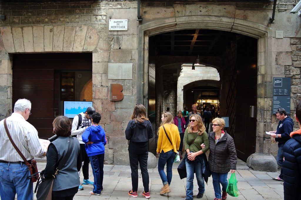 Museu Picasso. Visitants entrant i sortint per la porta principal al carrer de Montcada