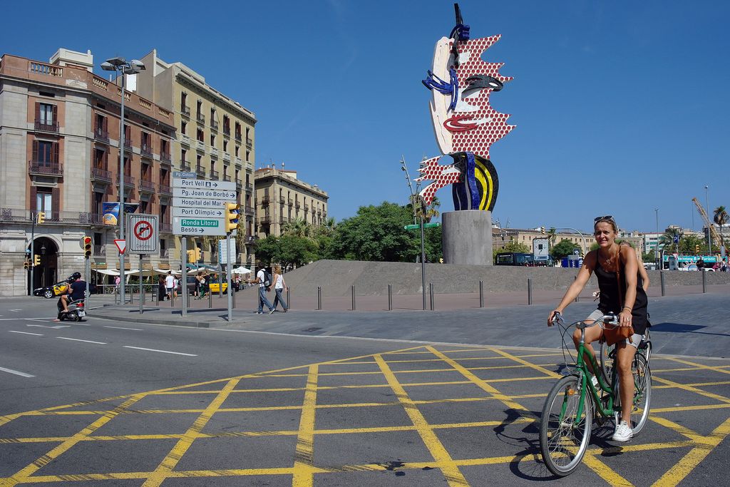 Ciclista passant per davant de l'escultura El cap de Barcelona, al passeig de Joan de Borbó Comte de Barcelona