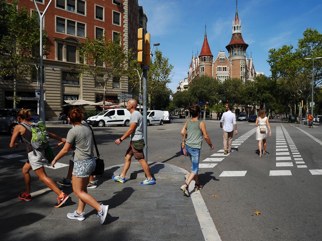 Casa de les Punxes. Persones al pas de vianants de davant