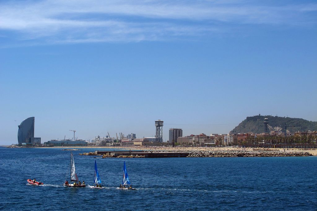 Platja de la Barceloneta. Forabord remolcant, mar endins, embarcacions de windsurf