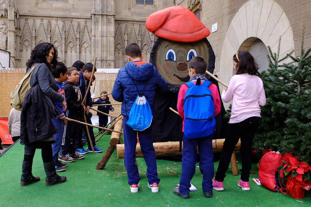 Nens fent cagar el tió gegant de la Fira de Santa Llúcia