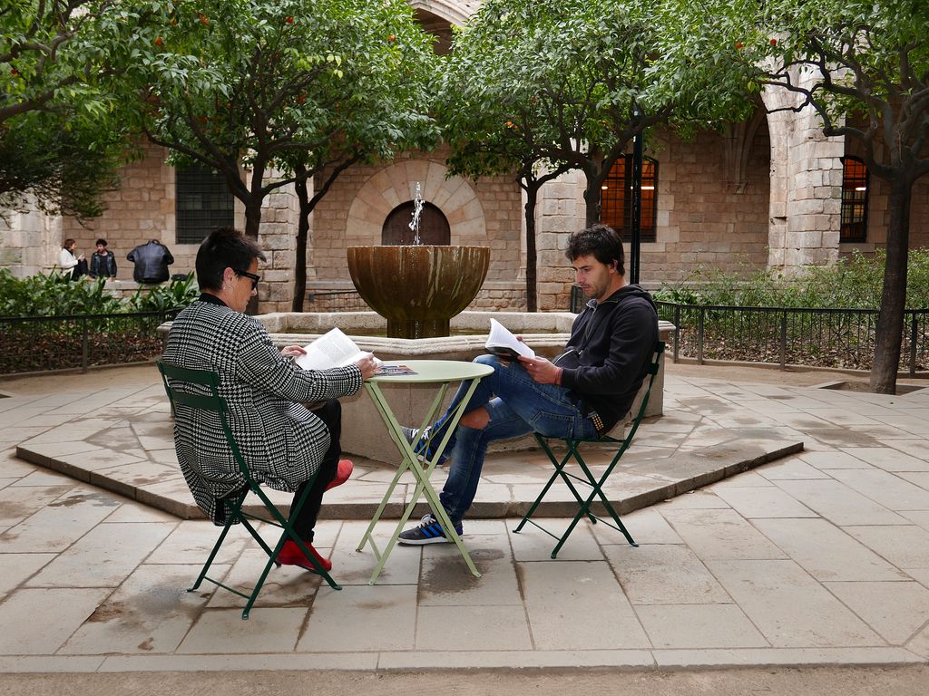 Pati de la Biblioteca de Catalunya amb persones llegint a les taules