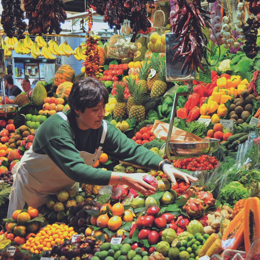 Mercat de la Boqueria. Venedora i parada de fruites i verdures.