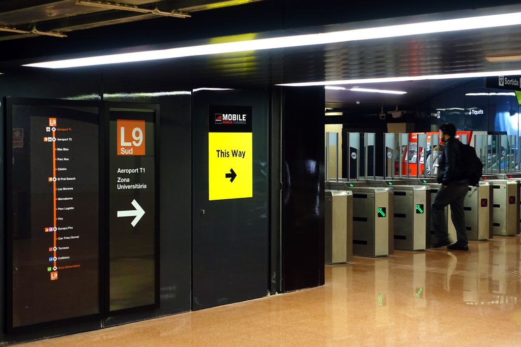 Línia 9 sud del metro, estació Zona Universitària. Senyalització informativa sobre la línia i torns