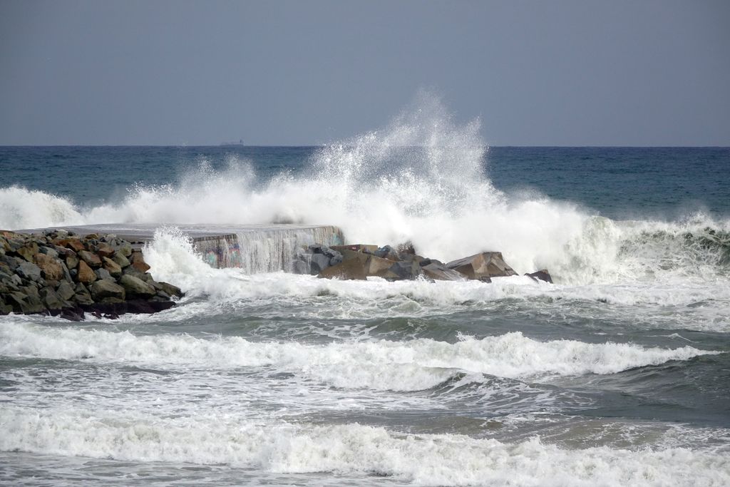 Vistes de la platja i del mar a la tardor. Onades colpejant el trencaonades