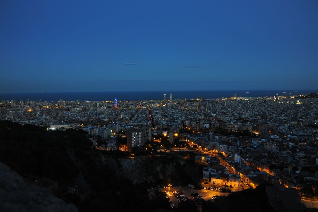 Vista nocturna de Barcelona de muntanya a mar amb l'Eixample i la Torre Glòries