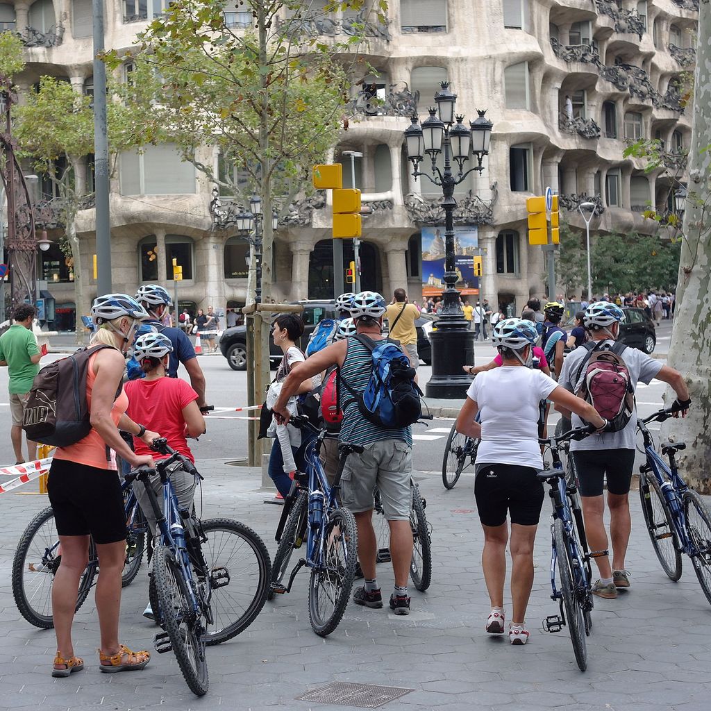 Grup de turistes en bicicleta davant la Pedrera