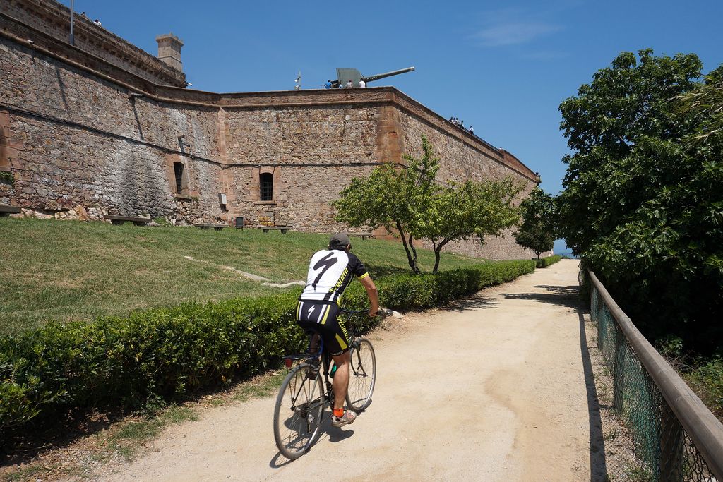 Camí del Mar. Ciclista passant davant del Castell de Montjuïc