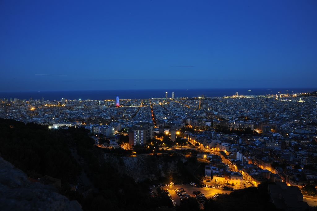 Vista nocturna de Barcelona de muntanya a mar amb l'Eixample i la Torre Glòries