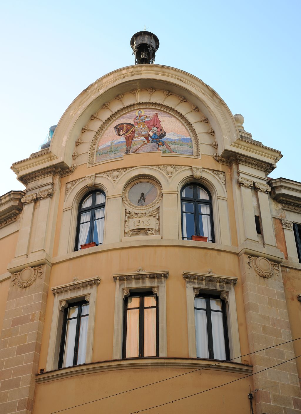 Antiga Caixa de Pensions al carrer del Clot. Coronament amb mosaic de Sant Martí a cavall