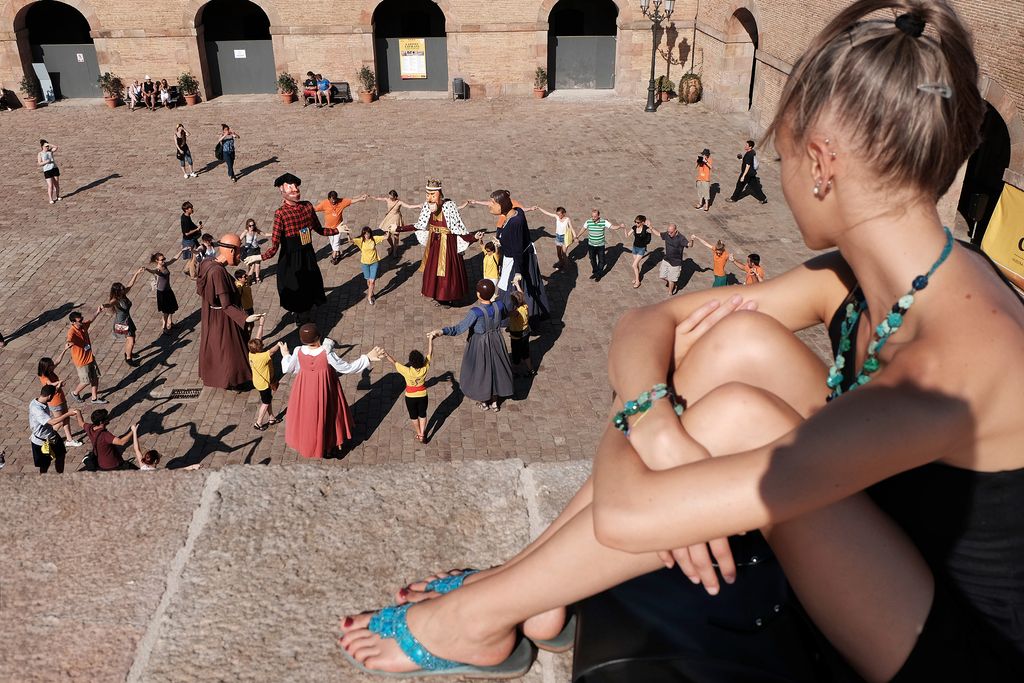 Danses tradicionals al Castell de Montjuïc. Visitant mirant les danses