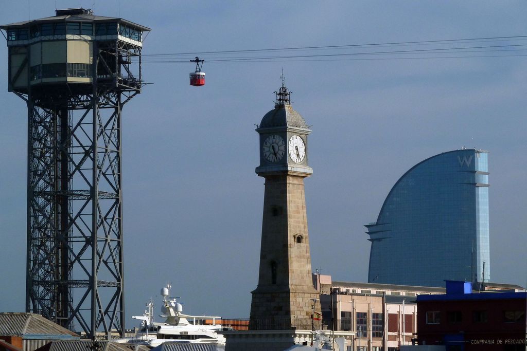 Port Vell. Torre del Rellotge amb la Torre de Sant Sebastià i l'Hotel Vela al fons