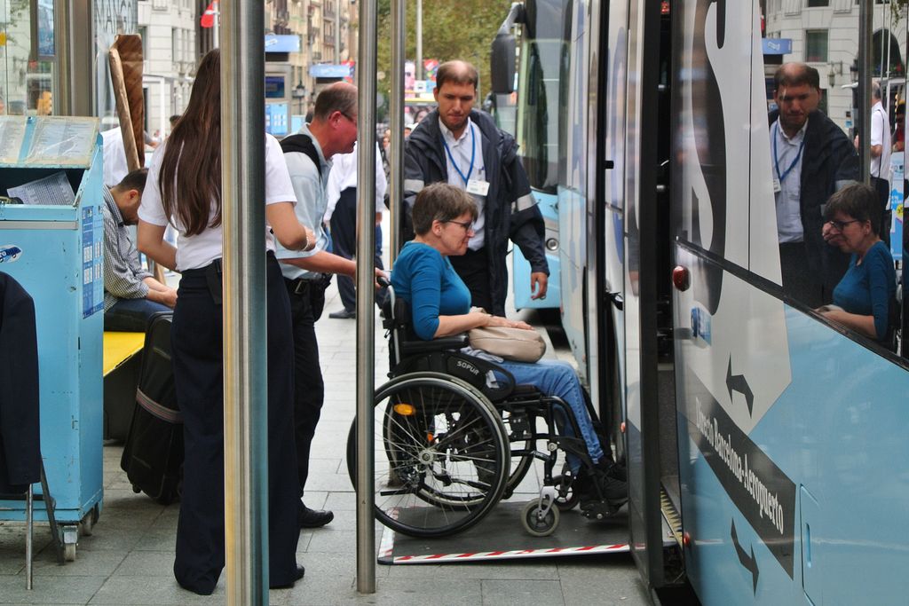 Aerobús. Passatgera amb mobilitat reduïda pujant a l'autobús per la rampa