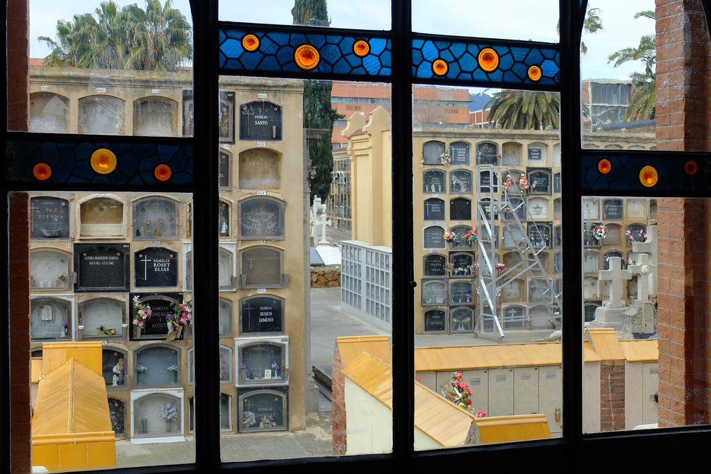 Cementiri de les Corts. Nínxols vistos des de darrere d'una finestra amb vitralls