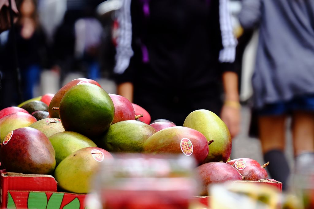 Verduleria amb una caixa de mangos a l'exterior