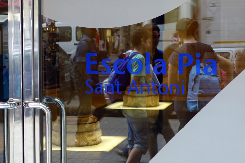 Escola Pia Sant Antoni. Rètol de la porta de vidre