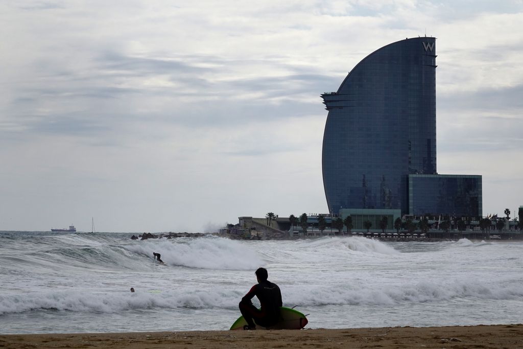 Platja de Sant Sebastià. Surfista assegut a la sorra