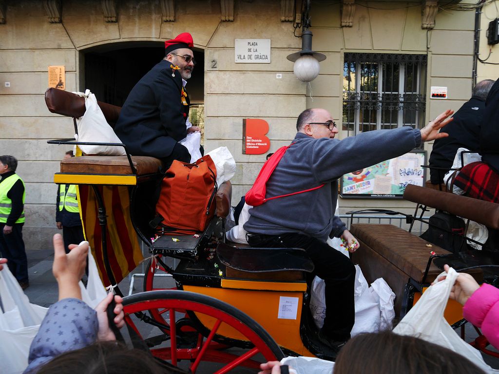 Sant Medir a Gràcia. Carruatge passant per davant de la seu del Districte i repartint caramels