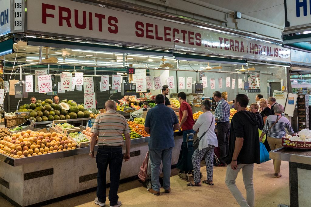 Parada de fruites i verdures del Mercat de Montserrat amb la clientela esperant per ser atesa