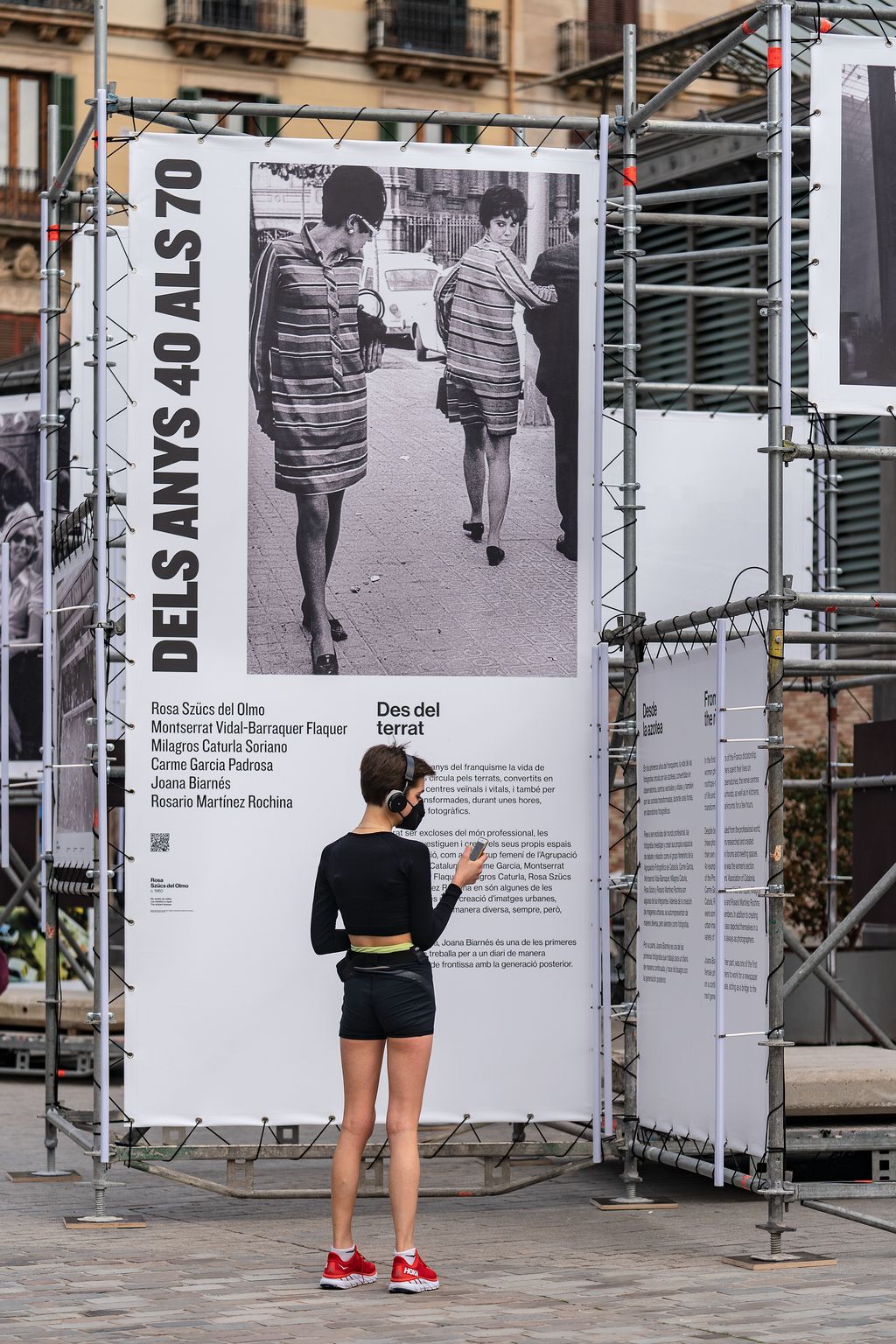Una jove visita l'exposició "Barcelona fotògrafes" a l'exterior del CCM El Born