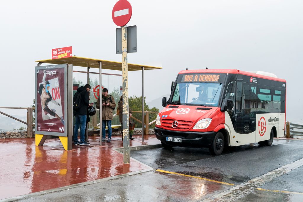 Bus del servei a demanda arribant a una parada amb passatgers esperant