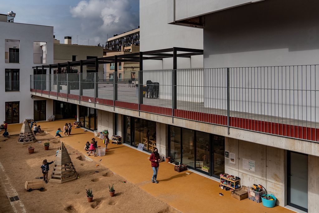 Pati amb classes d'educació infantil al voltant i infants jugant-hi al nou edifici de l'Escola Anglesola