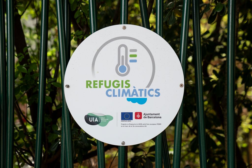Rètol amb el logotip dels refugis climàtics a la reixa d’una escola