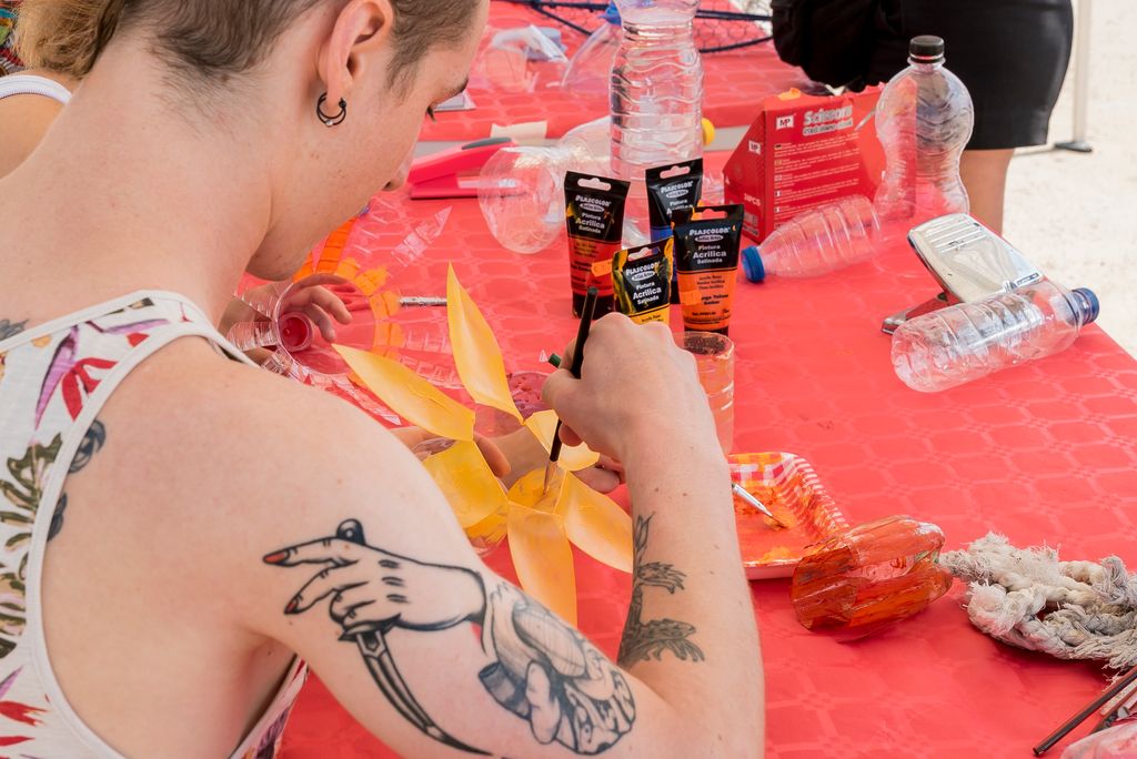 Artistes pintant el material reciclat per a la instal·lació artística de la platja