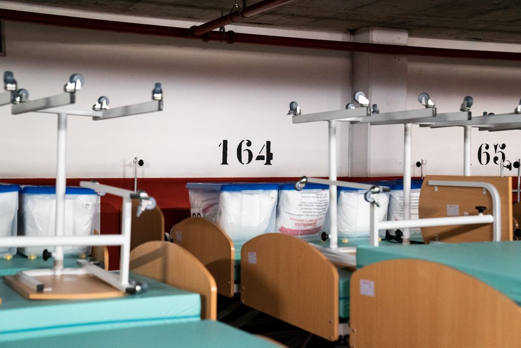 Llits amb matalassos, tauletes i caixes amb materials del Pavelló Salut Claror emmagatzemats a l'aparcament buit a l'espera de ser recollits