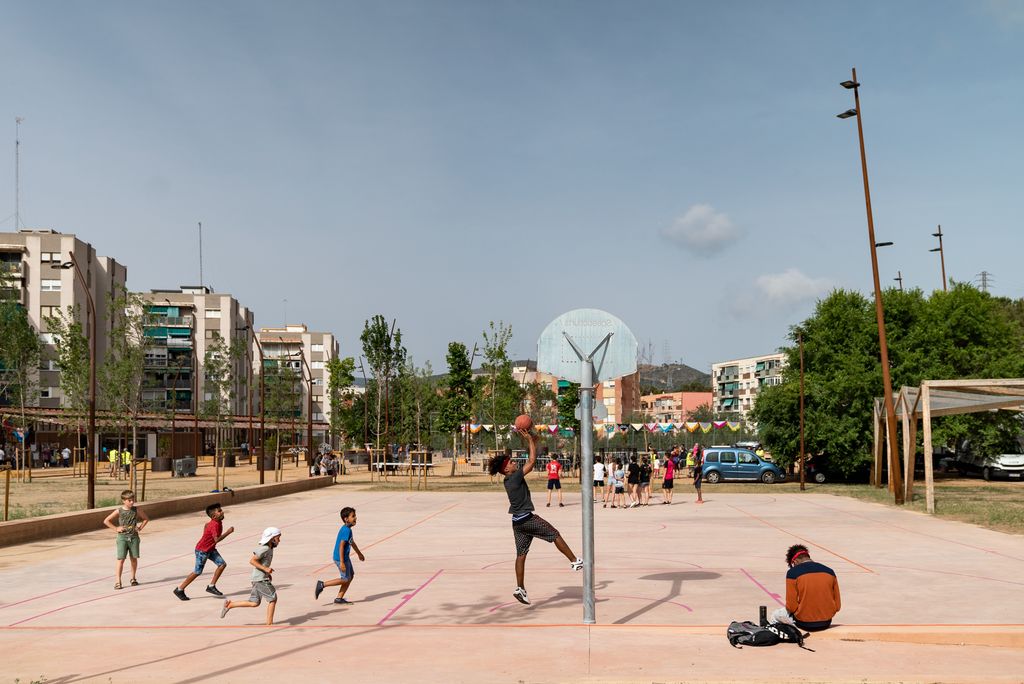 Nens jugant a bàsquet en una pista de ciment del parc de l’Aqüeducte que forma part de les noves instal·lacions esportives