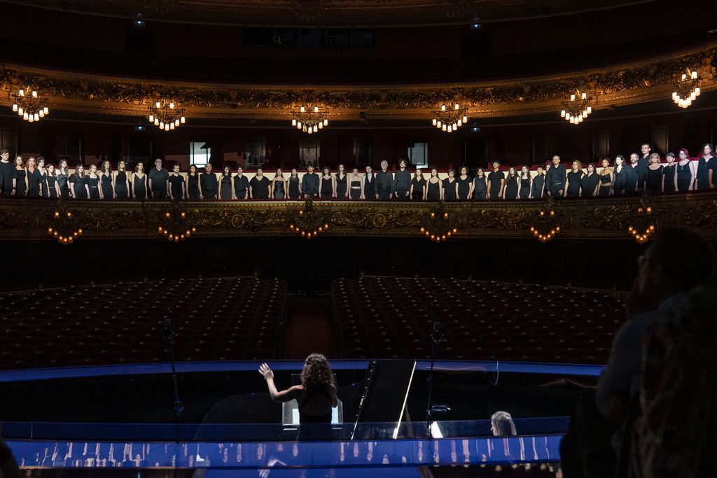 Cristina Colomer dirigint el cor amateur del barri del Raval durant la representació de l’òpera ‘La Gata Perduda’ del projecte europeu TRACTION al Gran Teatre del Liceu.