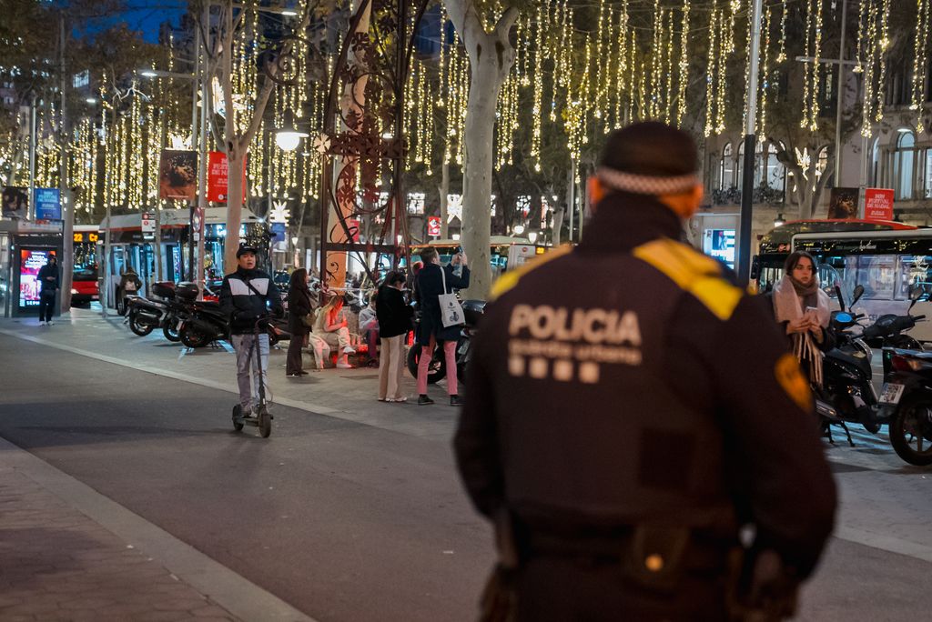 Un operatiu de la Guàrdia Urbana controla el carril dels vehicles mentre passa un patinet