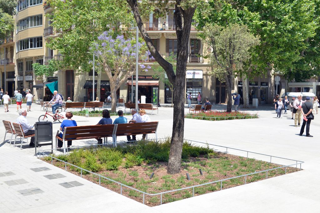Veïns asseguts i creuant una de les zones pacificades de la superilla de Sant Antoni, a la cruïlla del carrer del Comte Borrell