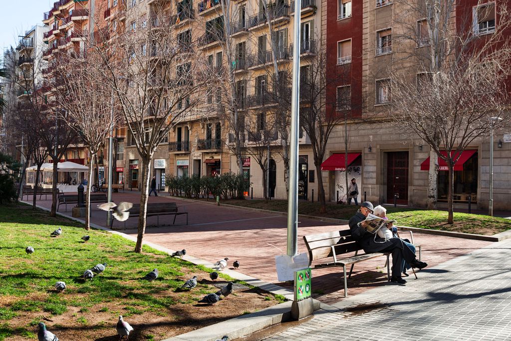 Parella de persones grans asseguda a un banc de l'Avinguda Mistral