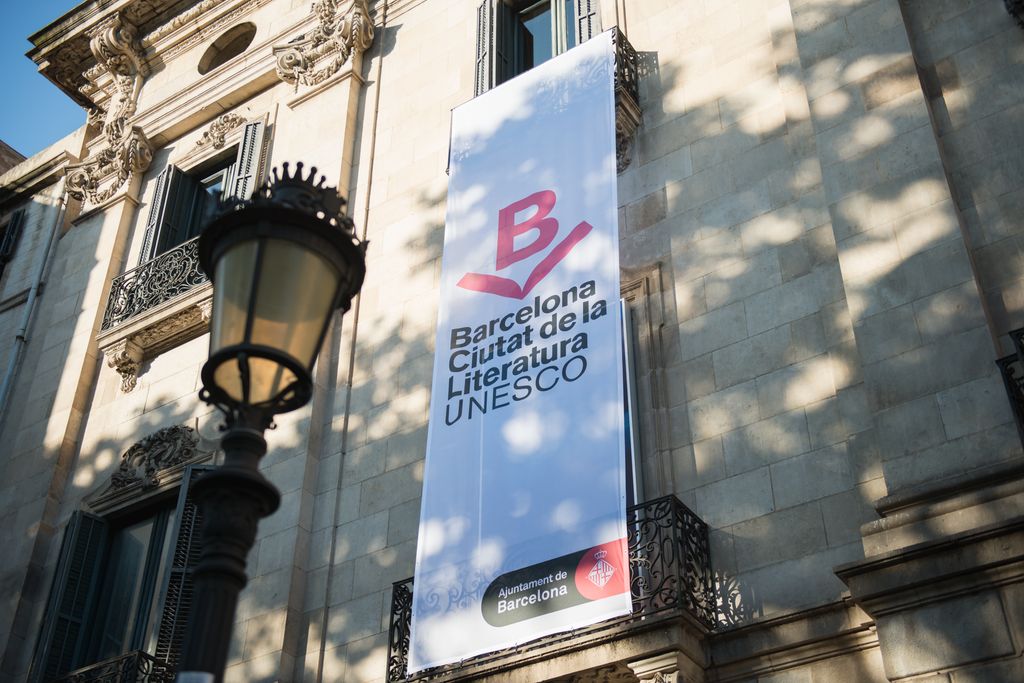 A la façana del Palau de la Virreina, una lona amb la imatge gràfica de Barcelona Ciutat de la Literatura UNESCO.