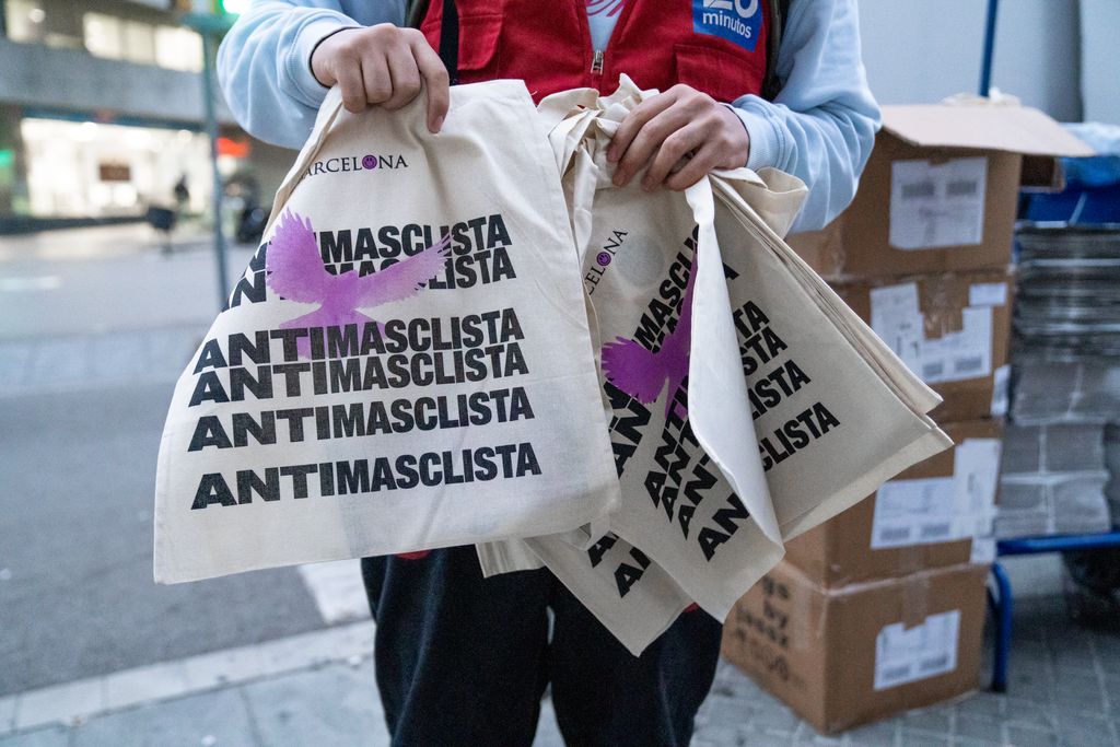 Repartiment de bosses del 25-N a la rambla de Catalunya cantonada amb Rosselló. Un dels repartidors de "20 Minutos" amb diverses bosses de la campanya Barcelona Antimasclista