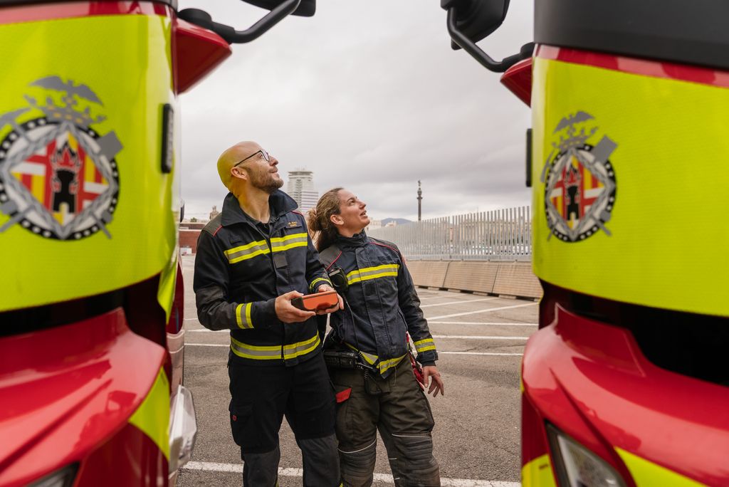 Un bomber i una bombera miren els vehicles nous de Bombers de Barcelona