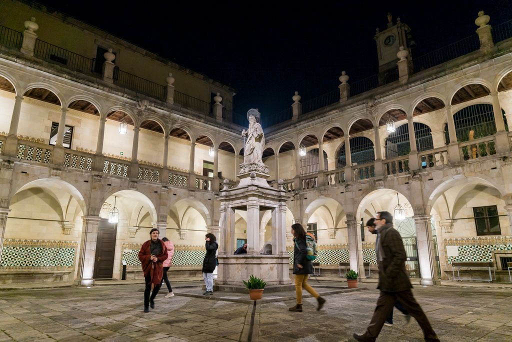 Visitants travessant el pati de l'Institut d'Estudis Catalans a la Casa de Convalescència amb l'estàtua de Sant Pau de Lluís Bonifaç