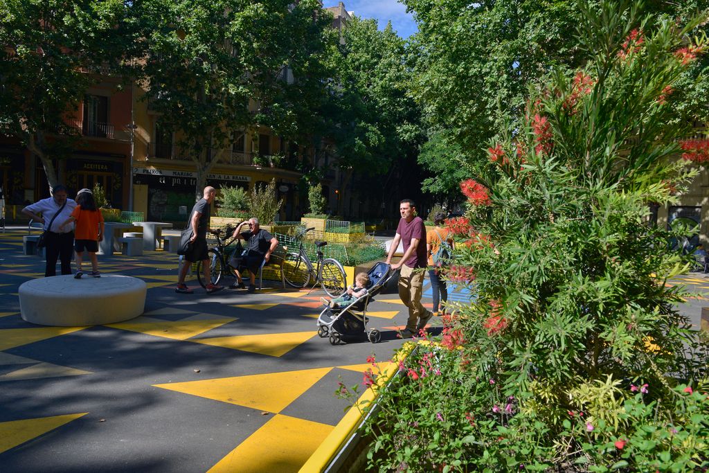 Zona de lleure i jocs infantils situada a la cruïlla del carrer del Comte Borrell amb Parlament, a la superilla de Sant Antoni. Hi ha famílies passejant i jugant amb infants i gent passejant i asseguda als bancs