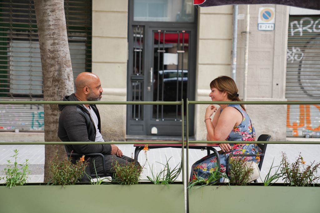 Clients asseguts en un dels nous prototips de terrasses en línia de Barcelona que conté unes barreres metàl·liques amb jardineres